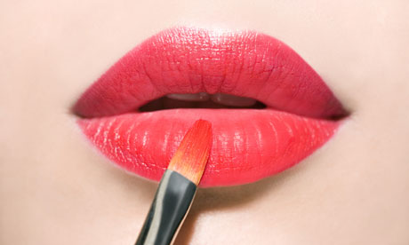 Woman applies red lipstick
